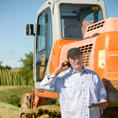A man in front of a tractor in the field.